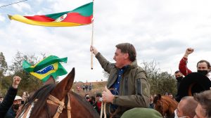 RS: Bolsonaro monta em cavalo e ergue bandeira do Estado. Em visita a Bagé, presidente conheceu uma das primeiras escolas cívico-militares do país