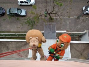 Porto Alegre: O leão Coragem e a formiga Vipinho descem de rapel do prédio do ICI nesse Dia da Criança